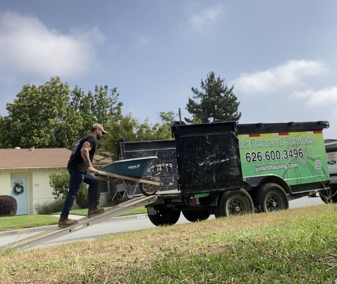 JunkFit crew loading wheelbarrow into trailer