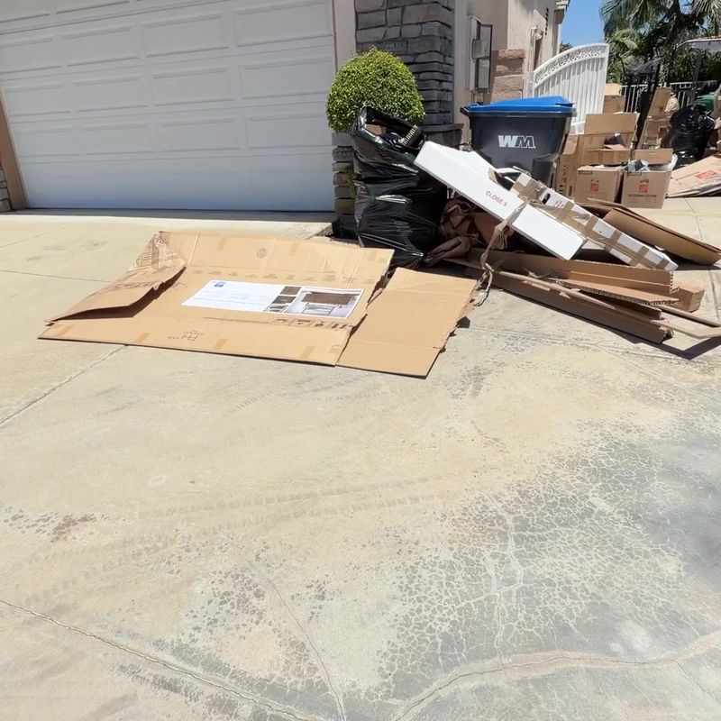 Driveway full of moving cardboard and boxes before junk removal in San Dimas