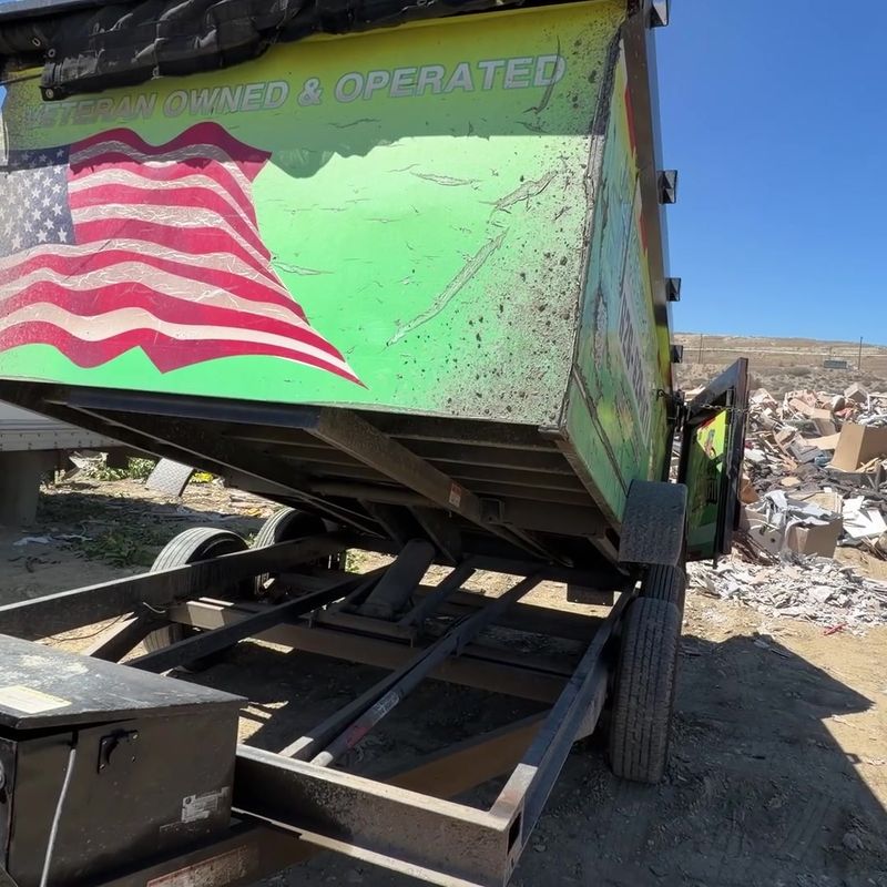 Veteran-owned JunkFit Hauling trailer unloading the San Dimas job