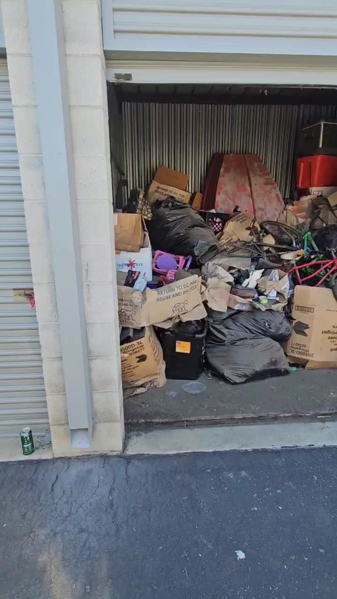 Before: Storage unit #397 in Glendora packed with boxes, bikes, trash bags, and furniture